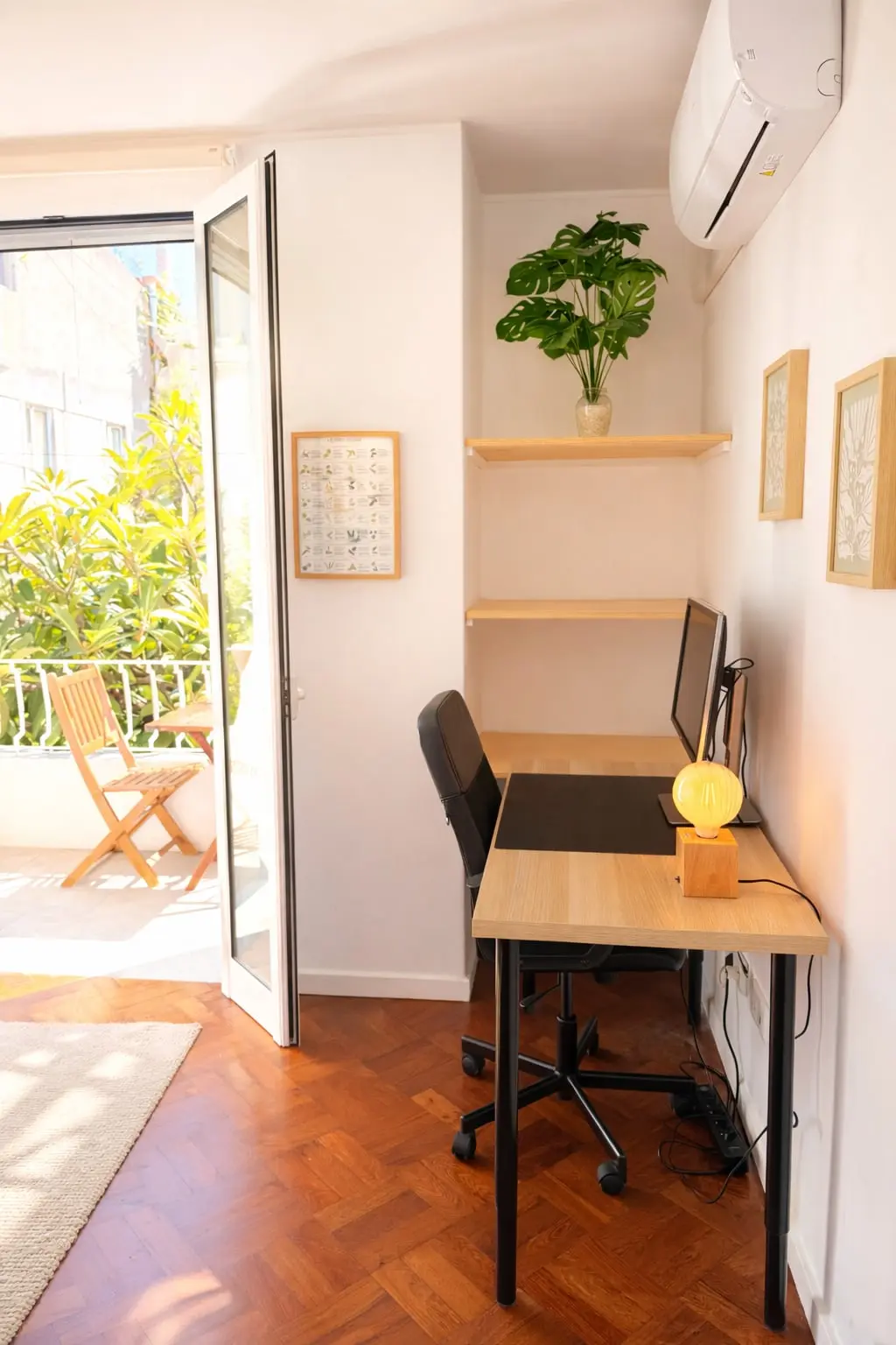 Bedroom desk with chair and lamp beside the open balcony door