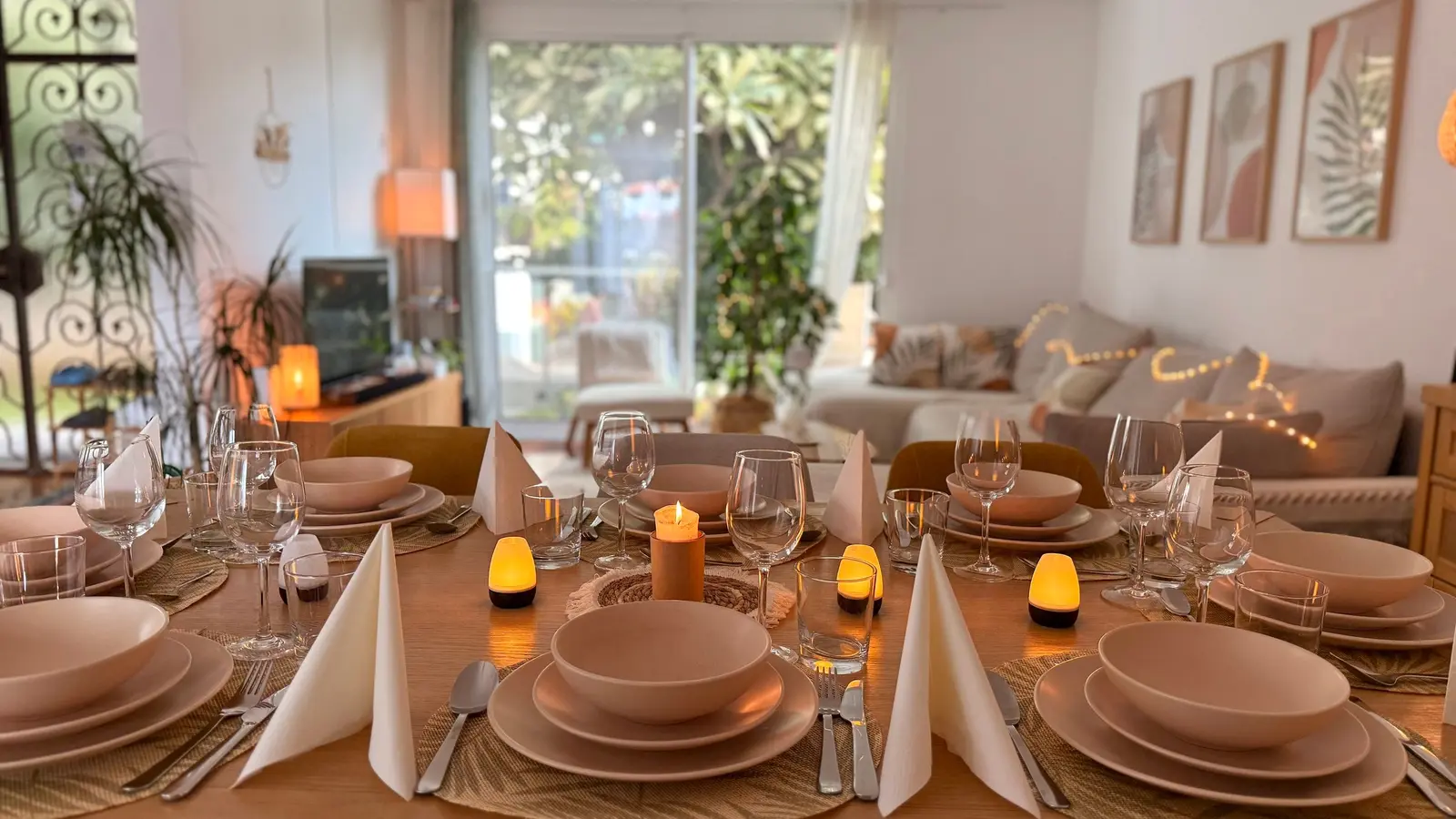 Dining table set for a candlelit dinner with the garden behind