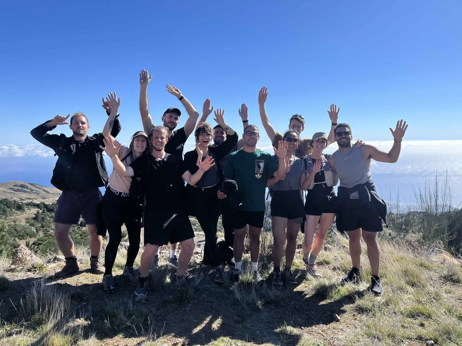 Hikers raising their arms on a sunny mountain ridge