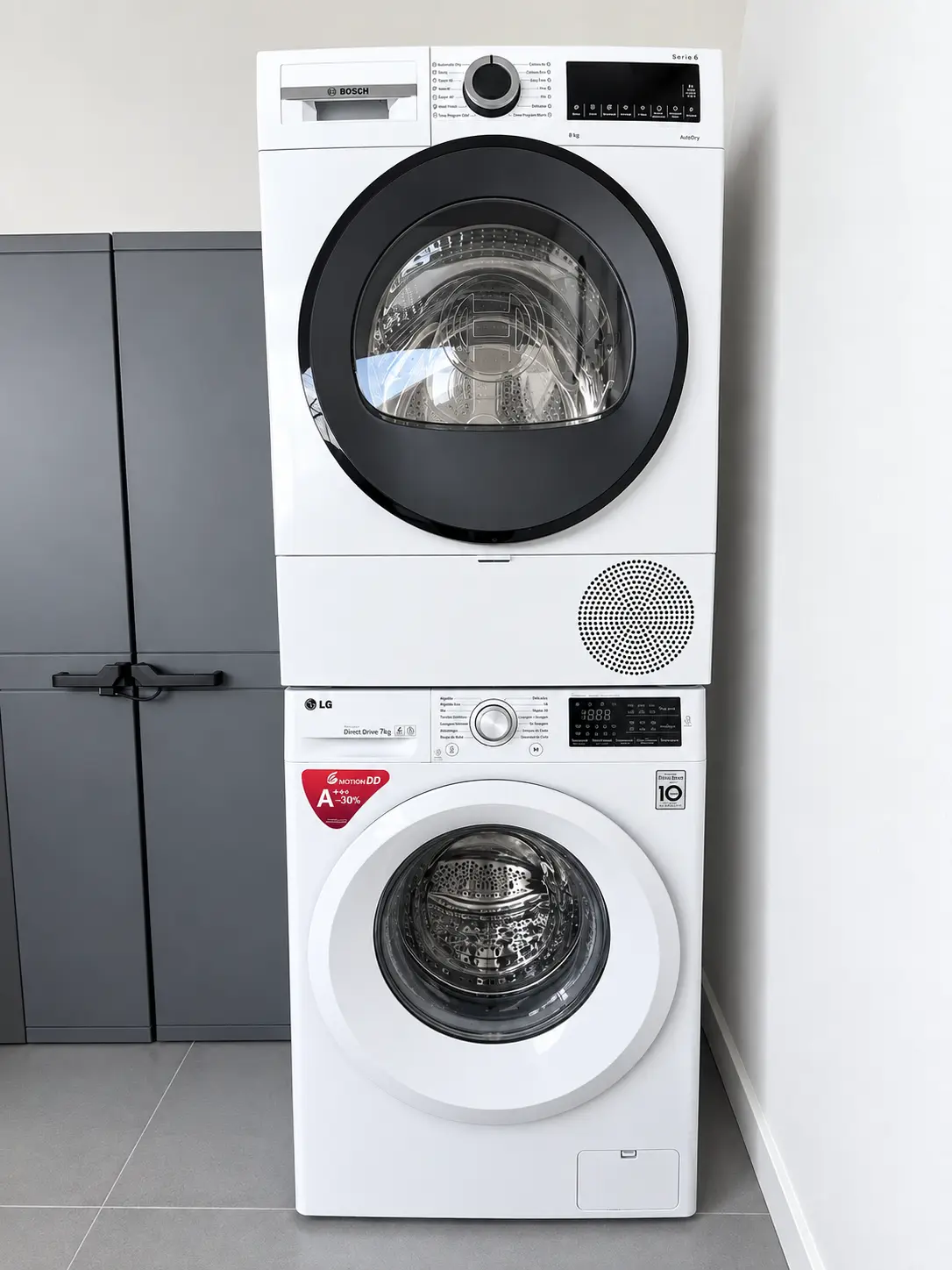 Washing machine with a tumble dryer stacked on top in the laundry area of the house