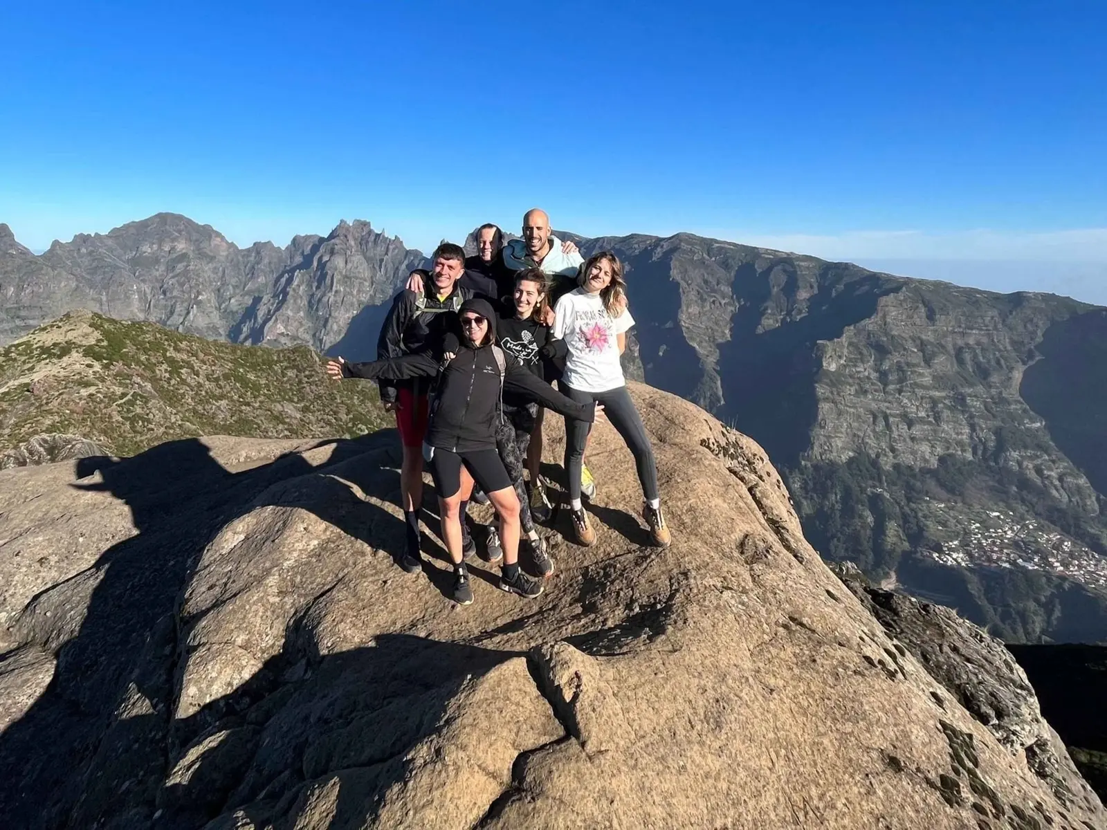 Group on a rocky summit with jagged mountains behind