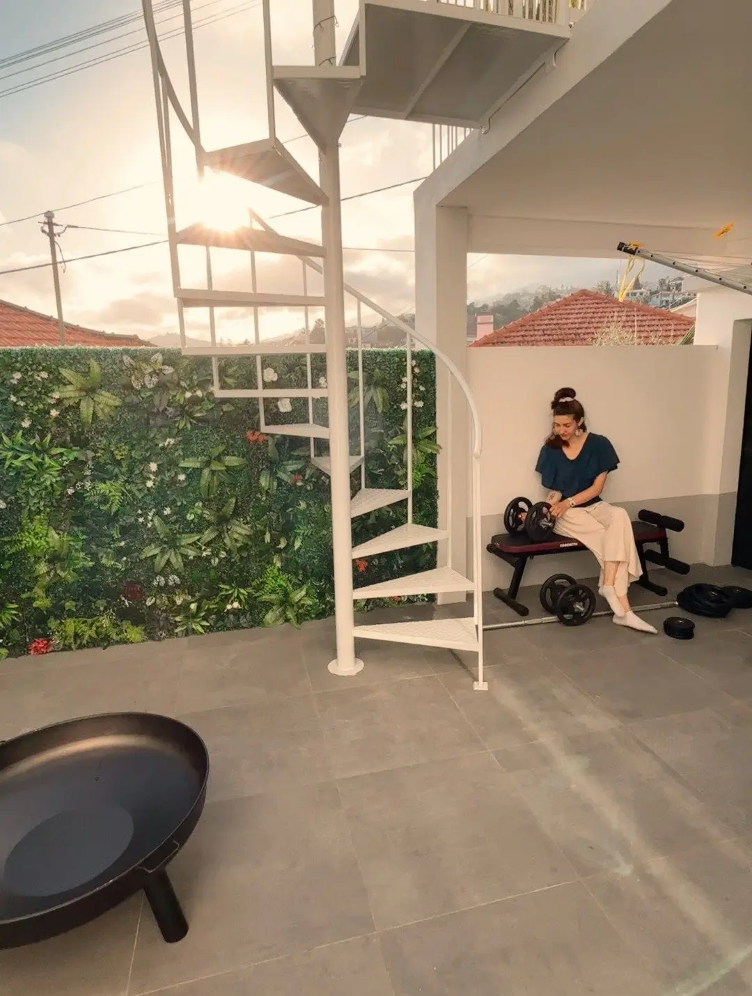 Rooftop area with spiral staircase, workout bench and green wall