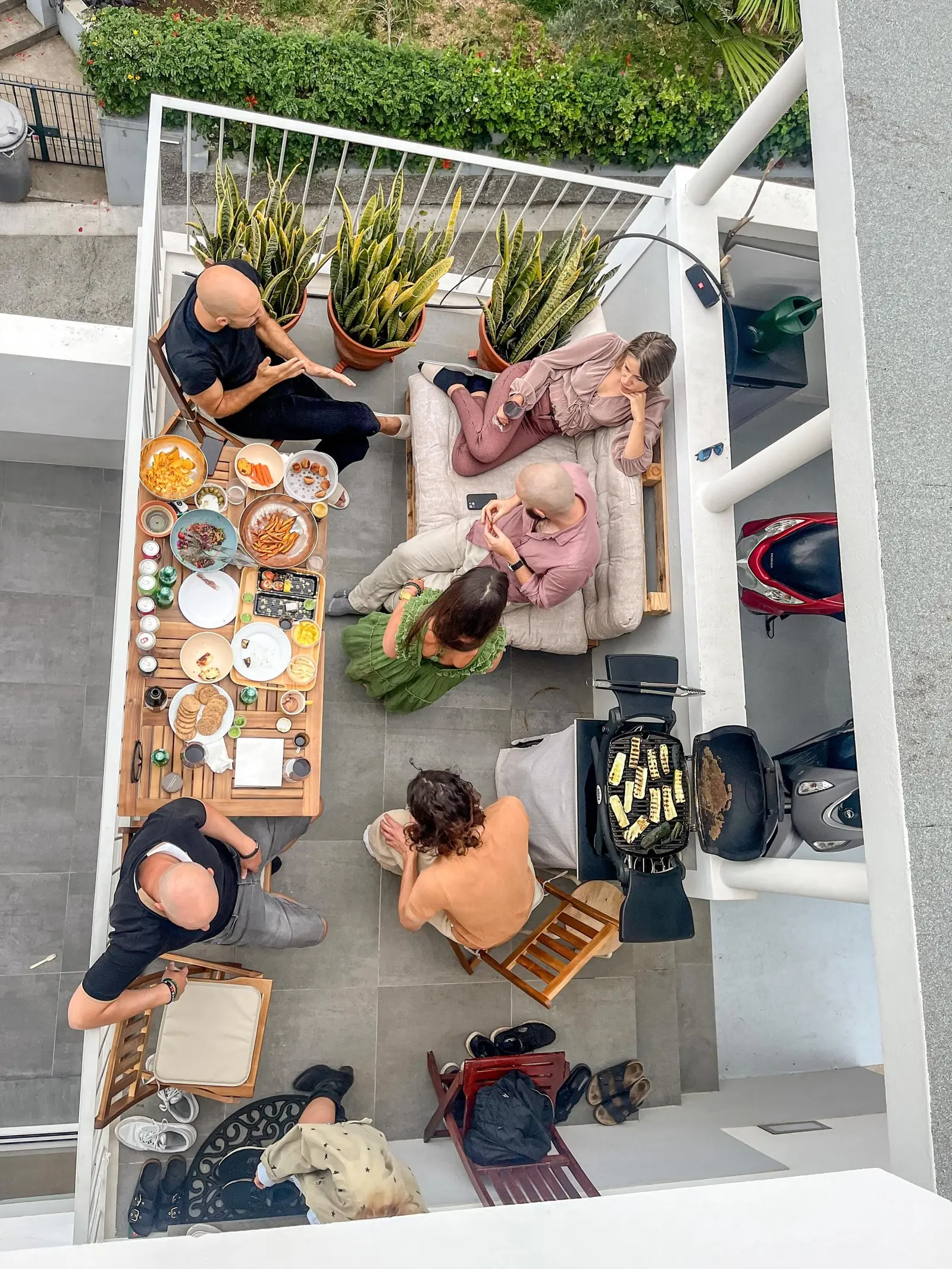 View from above of residents sharing a long brunch table on the terrace