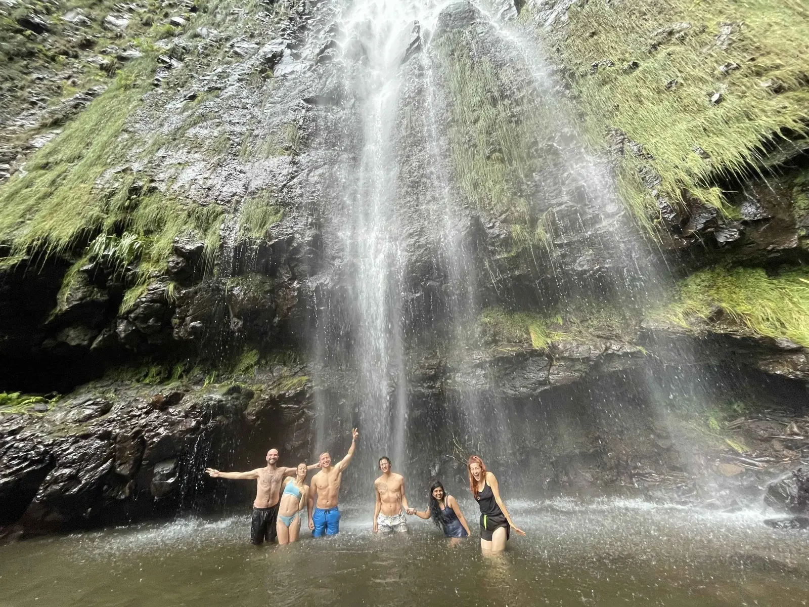 Residents swimming beneath a waterfall in Madeira